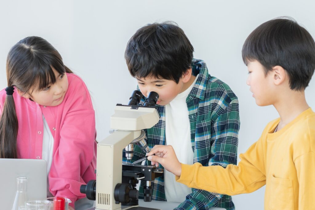 顕微鏡をのぞく小学生